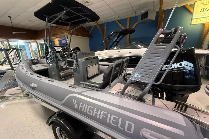 Slide: The Image of 2026 Highfield Sport 560 boat displayed indoors with Suzuki engine. - 3