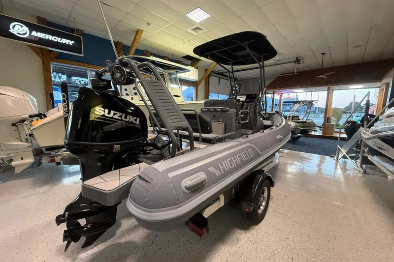 Slide: The Image of 2026 Highfield Sport 560 boat with Suzuki engine displayed in showroom. - 6