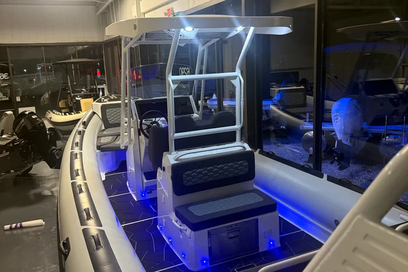 Slide: The Image of 2026 Highfield Sport 760 boat interior with blue LED lighting in showroom. - 13