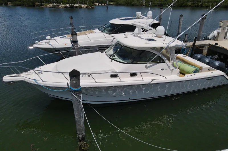 Slide: The Image of 2010 Pursuit OS 375 Offshore boat docked in a marina, side view. - 12