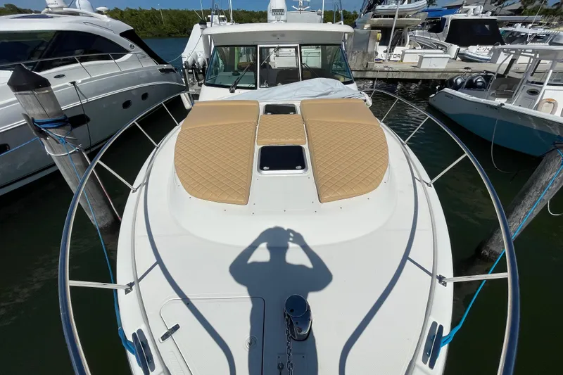 Slide: The Image of 2010 Pursuit OS 375 Offshore boat docked, featuring cushioned deck and sleek design. - 16