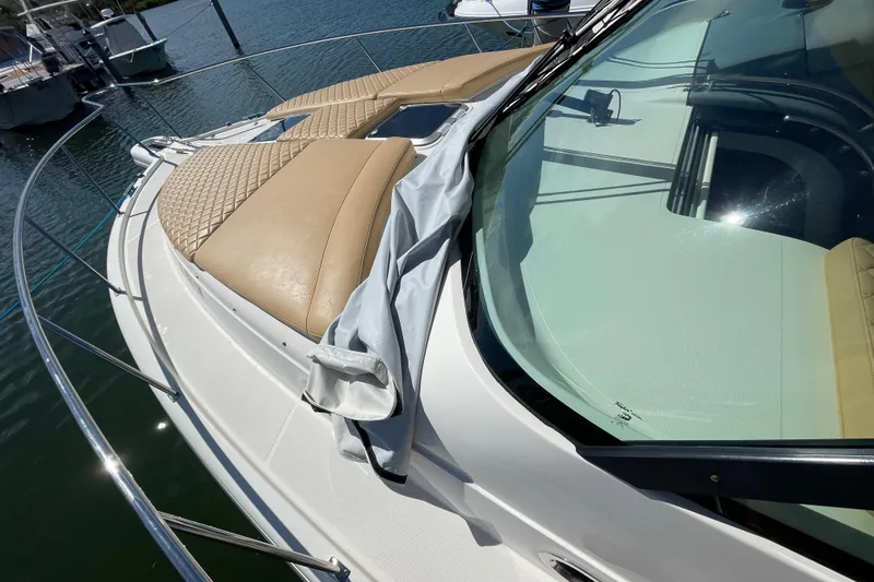 Slide: The Image of 2010 Pursuit OS 375 Offshore boat with tan cushions and sleek windshield design. - 19