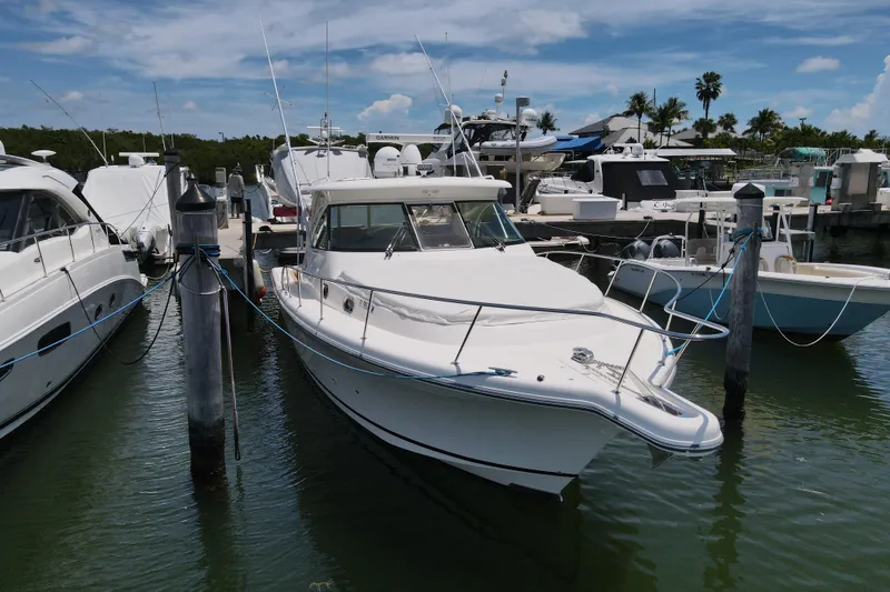 Slide: The Image of 2010 Pursuit OS 375 Offshore boat docked at marina under clear blue sky. - 2