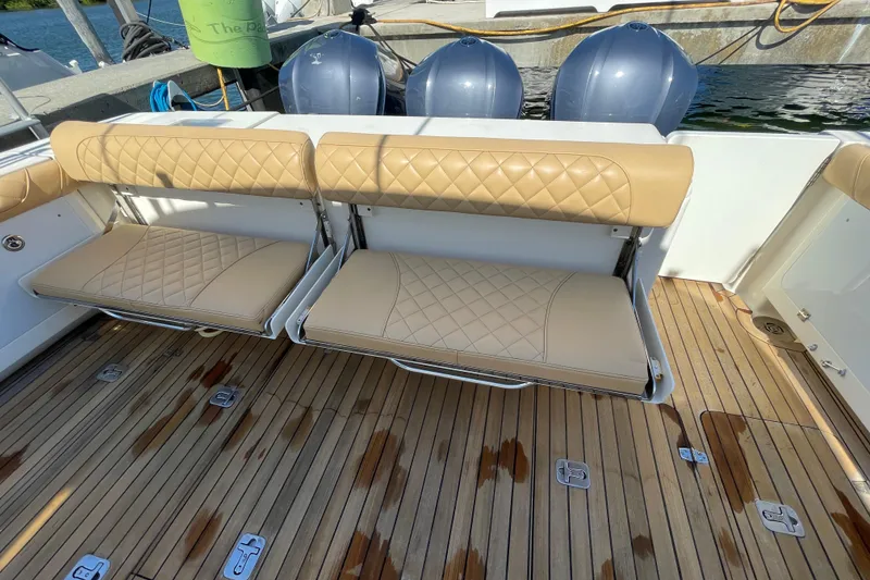 Slide: The Image of 2010 Pursuit OS 375 Offshore boat with tan cushioned seats and wooden deck. - 22