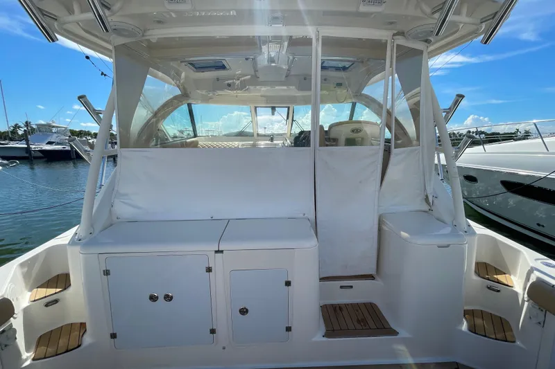 Slide: The Image of 2010 Pursuit OS 375 Offshore boat interior with seating and storage, docked at marina. - 23
