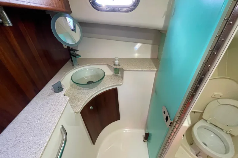 Slide: The Image of 2010 Pursuit OS 375 Offshore boat bathroom with glass sink and compact toilet. - 36
