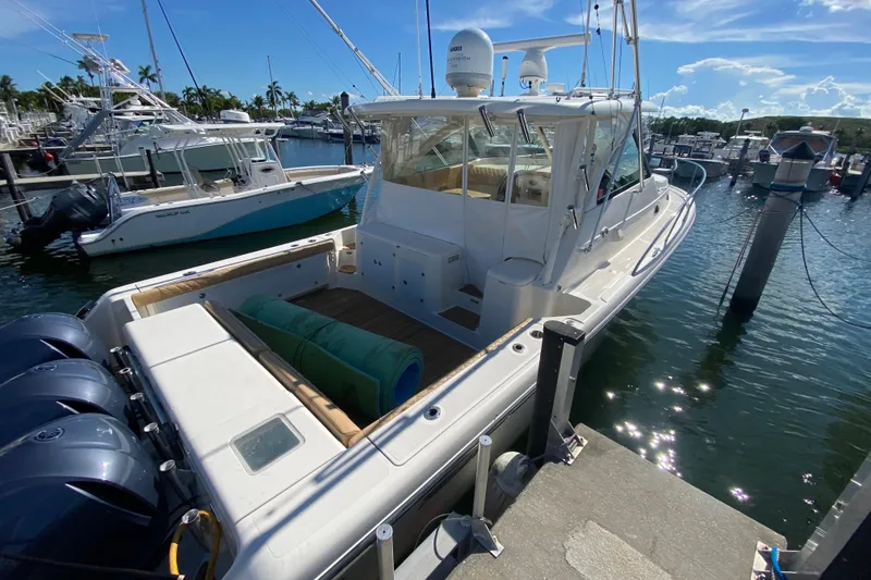 Slide: The Image of 2010 Pursuit OS 375 Offshore boat docked at marina under clear blue sky. - 42