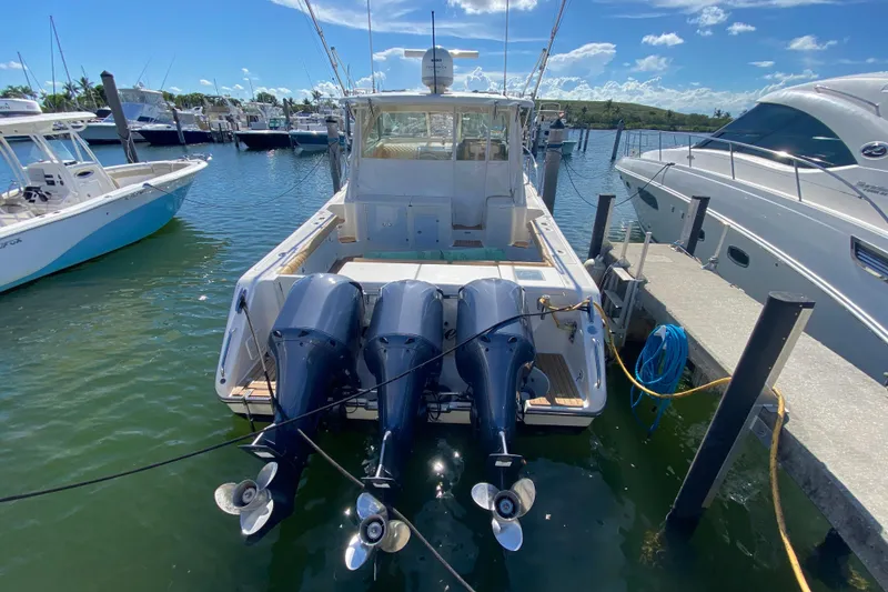 Slide: The Image of 2010 Pursuit OS 375 Offshore boat docked with triple outboard engines. - 43