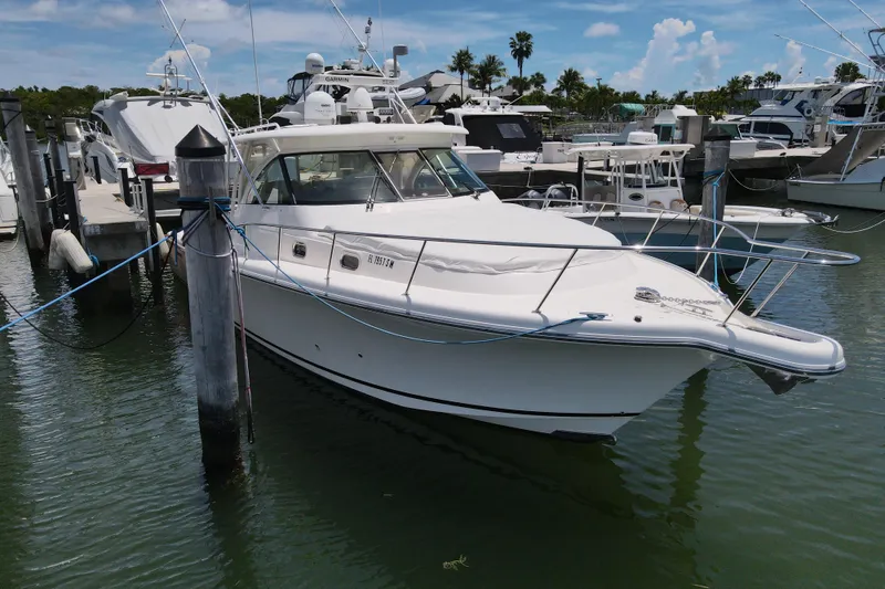 Slide: The Image of 2010 Pursuit OS 375 Offshore boat docked at marina, surrounded by other vessels. - 6