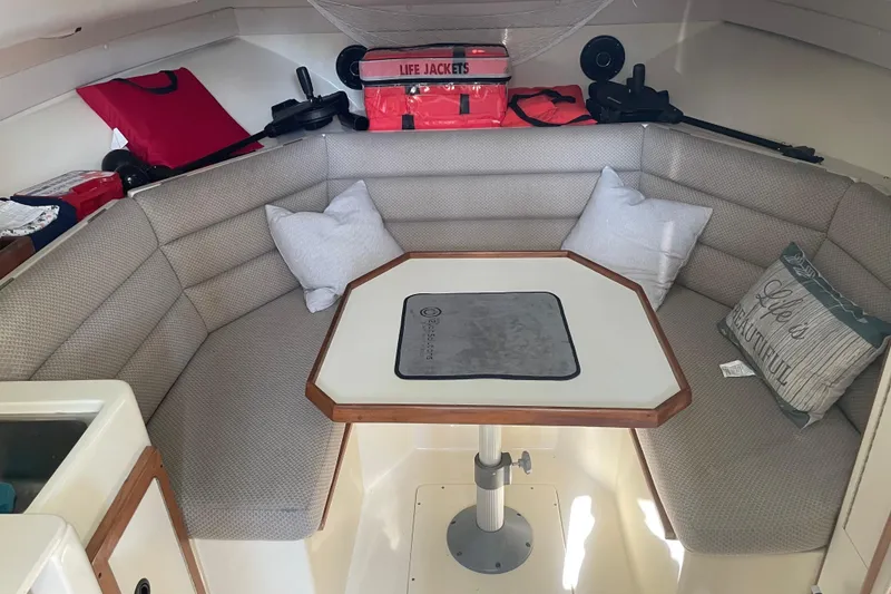 Slide: The Image of Cozy interior of 1999 Albin 28 Tournament Express with cushioned seating and table. - 4