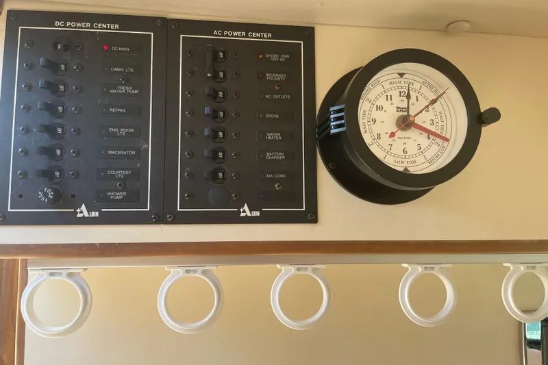 Slide: The Image of 1999 Albin 28 Tournament Express power panels and tide clock inside cabin. - 7