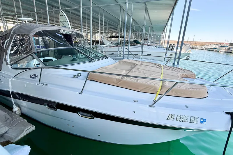 Slide: The Image of 2004 Four Winns 298 Vista boat docked in marina, covered seating area, calm water. - 11