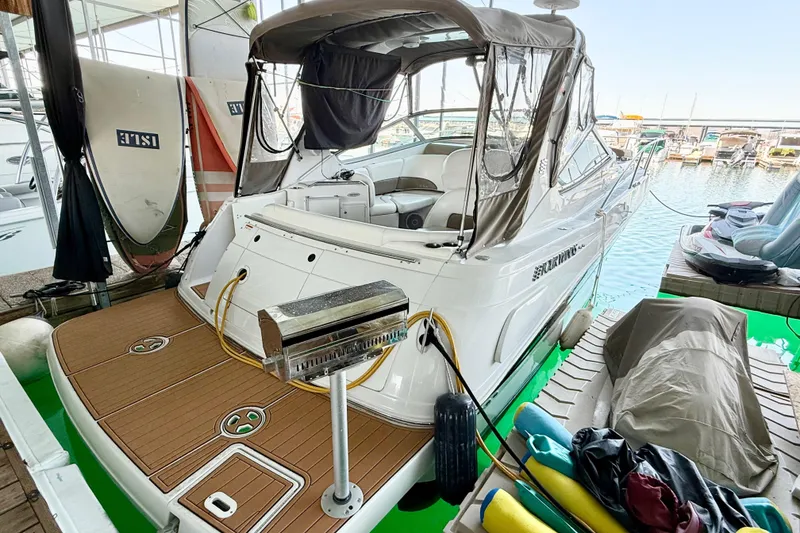 Slide: The Image of 2004 Four Winns 298 Vista boat docked with covered seating and equipment nearby. - 14