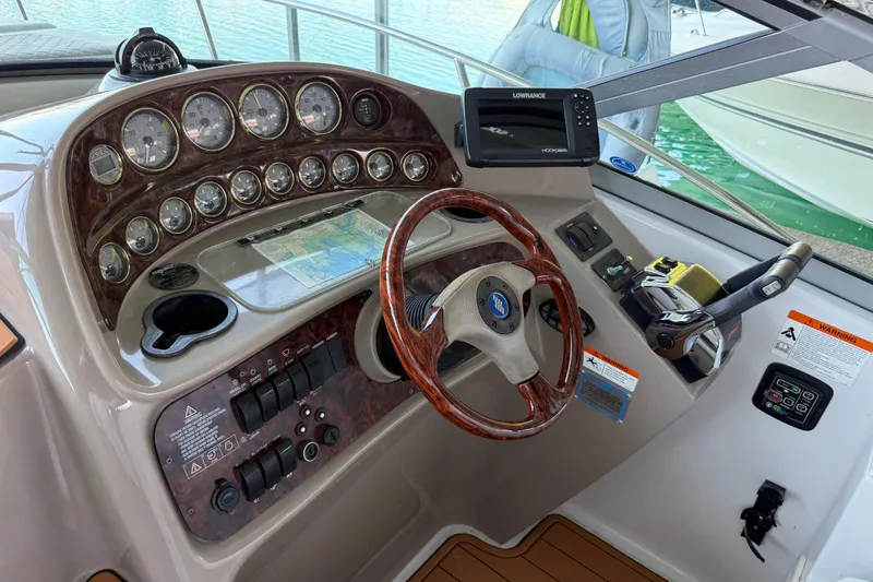 Slide: The Image of 2004 Four Winns 298 Vista boat dashboard with gauges, steering wheel, and navigation equipment. - 19