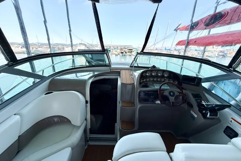 Slide: The Image of 2004 Four Winns 298 Vista boat cockpit with steering wheel and dashboard, docked in marina. - 21