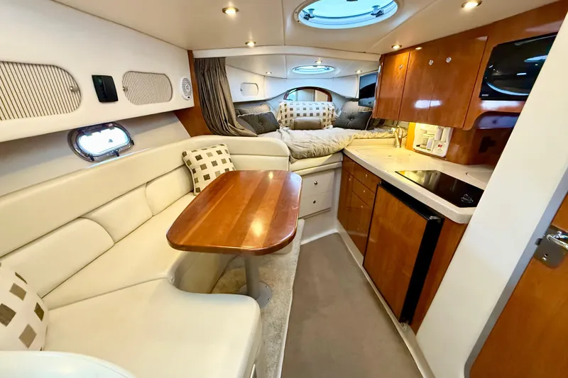 Slide: The Image of Luxurious 2004 Four Winns 298 Vista cabin interior with kitchen, seating, and sleeping area. - 26