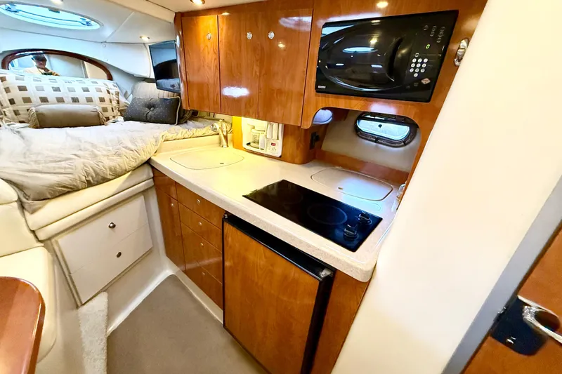 Slide: The Image of 2004 Four Winns 298 Vista cabin interior with kitchenette and cozy sleeping area. - 29