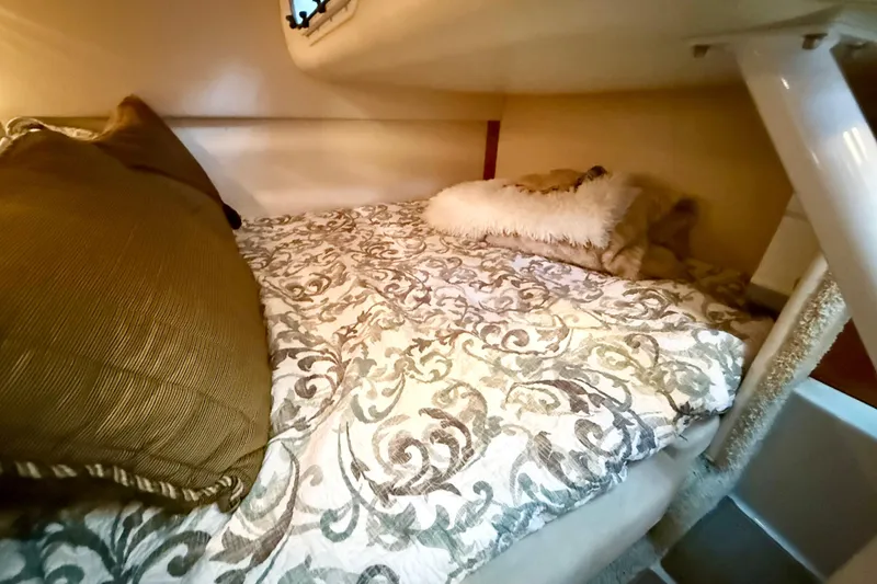 Slide: The Image of Cozy cabin interior of 2004 Four Winns 298 Vista with patterned bedding and pillows. - 31