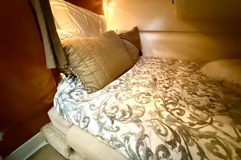 Slide: The Image of Cozy cabin bed in 2004 Four Winns 298 Vista boat with patterned bedding and soft lighting. - 32