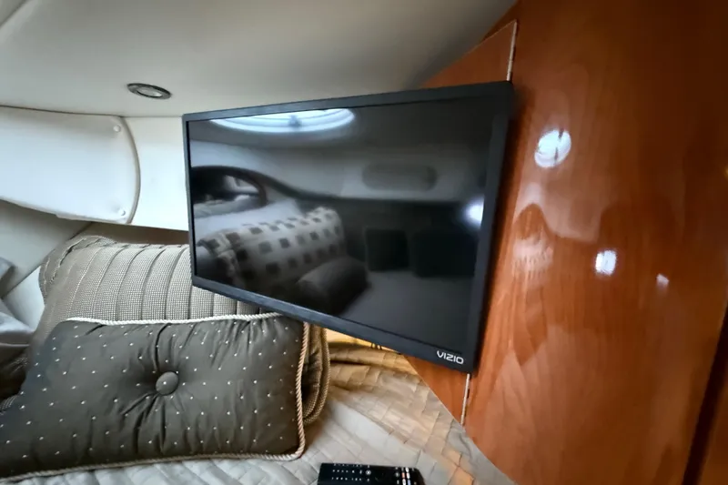 Slide: The Image of Interior of 2004 Four Winns 298 Vista with mounted Vizio TV and plush bedding. - 35