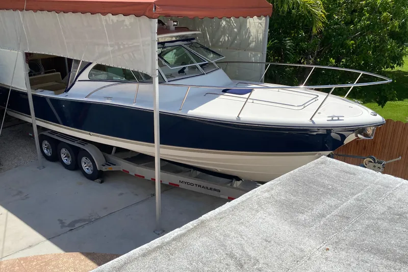 Slide: The Image of 2006 Pursuit 3480 Drummond Island Runner boat on trailer under canopy. - 11