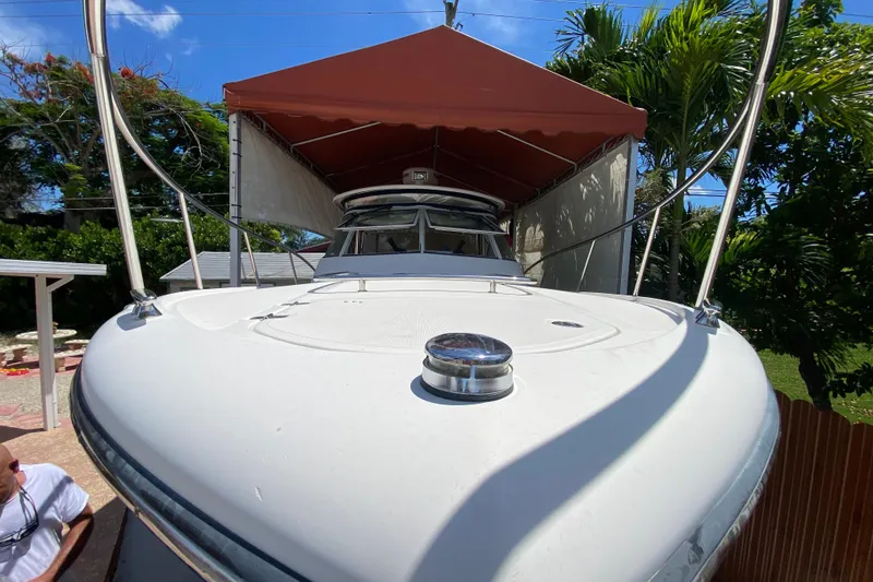 Slide: The Image of 2006 Pursuit 3480 Drummond Island Runner boat under canopy, surrounded by tropical greenery. - 12