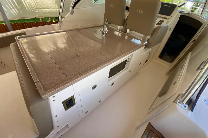 Slide: The Image of 2006 Pursuit 3480 Drummond Island Runner interior with kitchenette and seating area. - 23