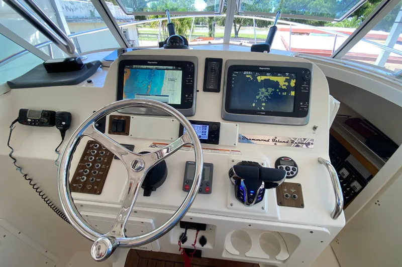 Slide: The Image of Helm of 2006 Pursuit 3480 Drummond Island Runner with navigation screens and controls. - 27