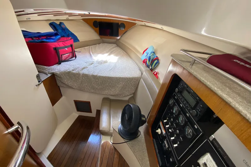 Slide: The Image of 2006 Pursuit 3480 Drummond Island Runner cabin interior with bed, fan, and control panel. - 32