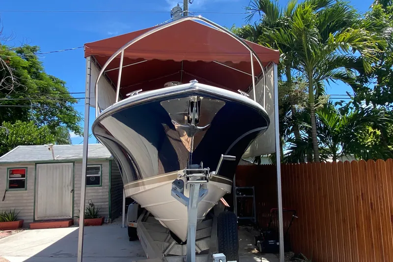 Slide: The Image of 2006 Pursuit 3480 Drummond Island Runner boat under canopy, surrounded by tropical plants. - 4