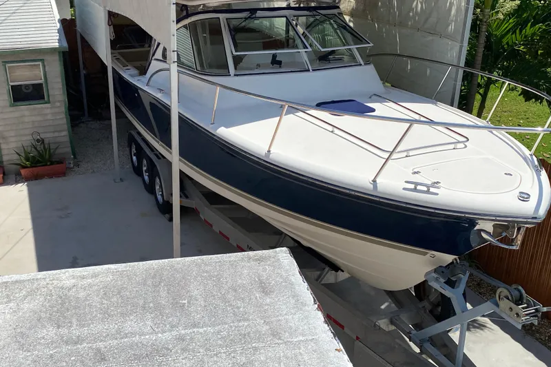 Slide: The Image of 2006 Pursuit 3480 Drummond Island Runner boat on trailer, parked in driveway. - 6