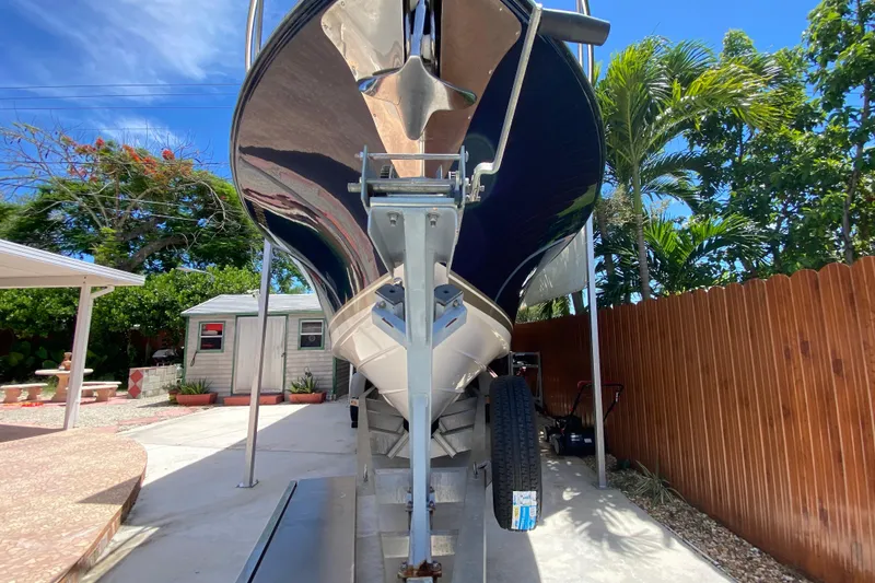 Slide: The Image of 2006 Pursuit 3480 Drummond Island Runner boat on trailer, surrounded by tropical foliage. - 7