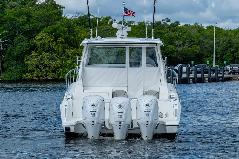 Slide: The Image of 2022 Pursuit OS 355 Offshore boat with triple outboard engines on water. - 10