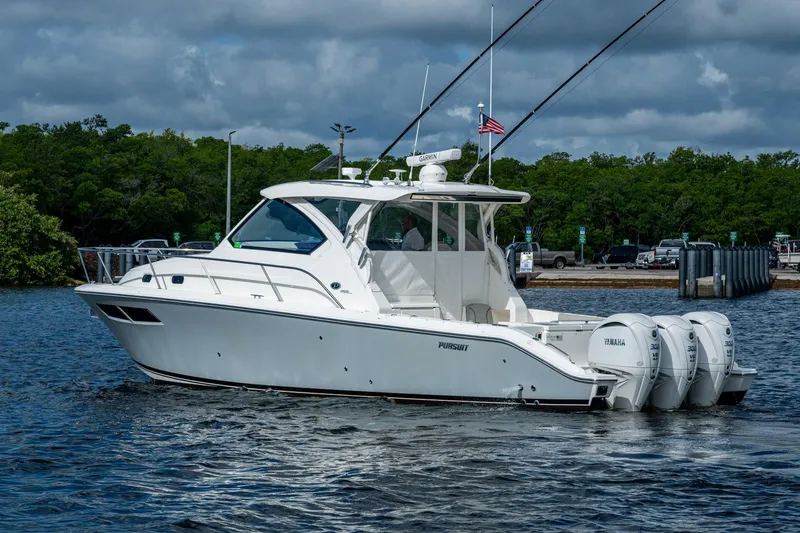 Slide: The Image of 2022 Pursuit OS 355 Offshore boat with triple Yamaha engines on water. - 11