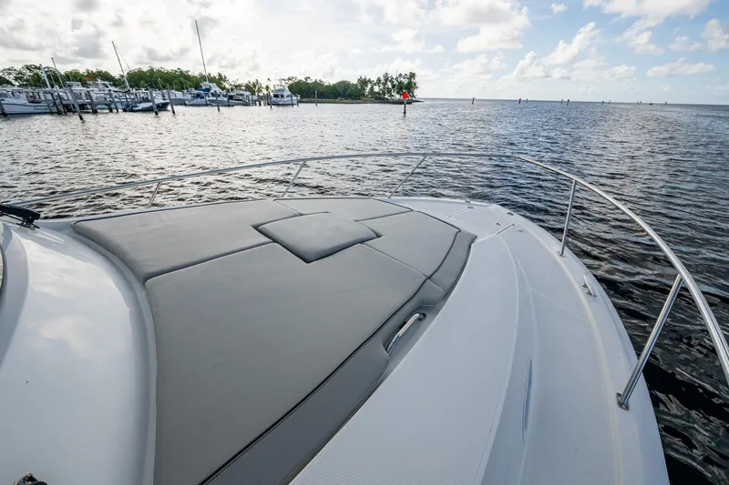 Slide: The Image of 2022 Pursuit OS 355 Offshore boat with cushioned deck, docked near marina. - 16