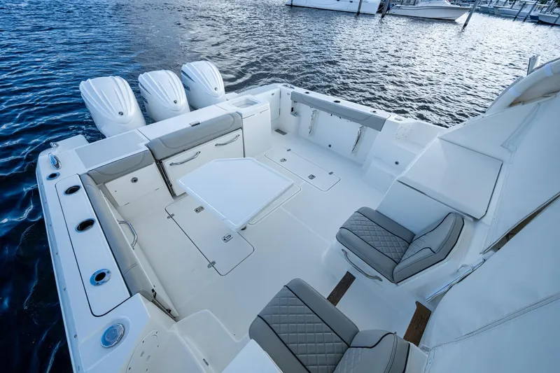 Slide: The Image of 2022 Pursuit OS 355 Offshore boat interior with seating and table on water. - 27