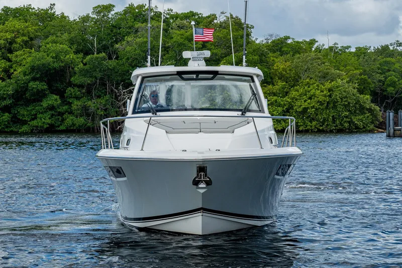 Slide: The Image of 2022 Pursuit OS 355 Offshore boat on water, front view with American flag. - 3