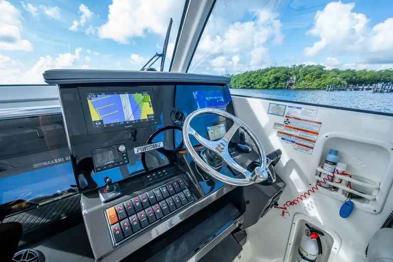 Slide: The Image of Cockpit of 2022 Pursuit OS 355 Offshore boat with navigation screens and steering wheel. - 38
