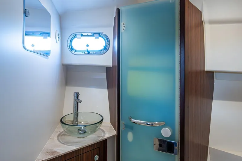 Slide: The Image of 2022 Pursuit OS 355 Offshore cabin interior with wood paneling and bed. - 51