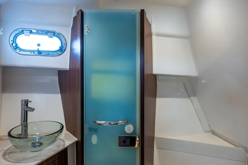 Slide: The Image of 2022 Pursuit OS 355 Offshore bathroom with glass sink and frosted door. - 52
