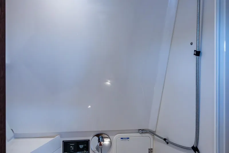 Slide: The Image of 2022 Pursuit OS 355 Offshore bathroom with glass sink and frosted door. - 53
