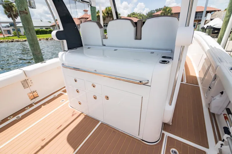 Slide: The Image of 2016 Edgewater 368CC boat interior with sleek white cabinetry and wood-textured flooring. - 12