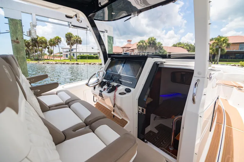 Slide: The Image of 2016 Edgewater 368CC boat interior with helm, seating, and waterfront view. - 14