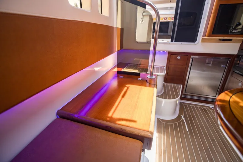 Slide: The Image of Interior of 2016 Edgewater 368CC boat with wood accents and ambient lighting. - 26