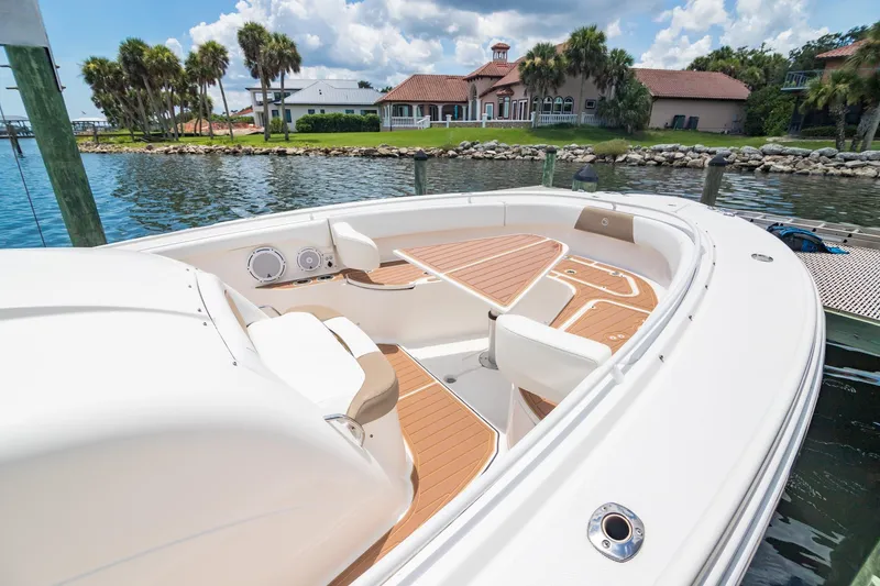 Slide: The Image of 2016 Edgewater 368CC boat with spacious deck, docked near waterfront homes. - 30