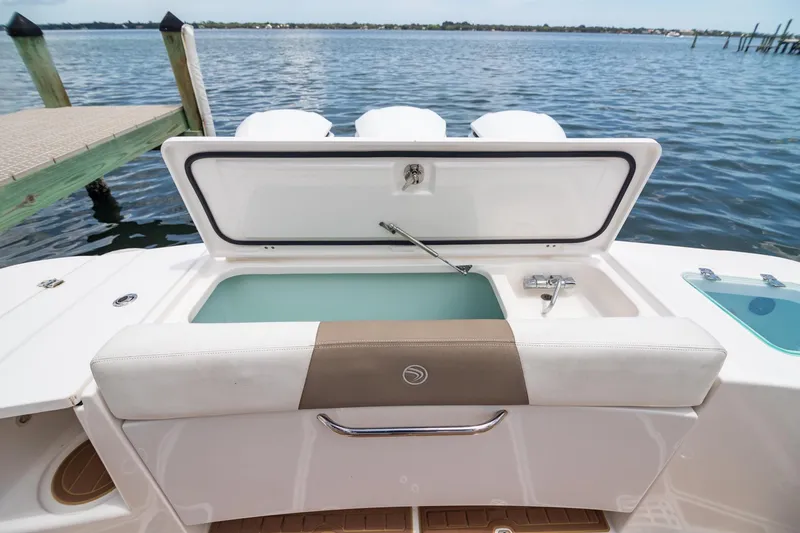 Slide: The Image of 2016 Edgewater 368CC boat with open storage compartment, docked by the water. - 6