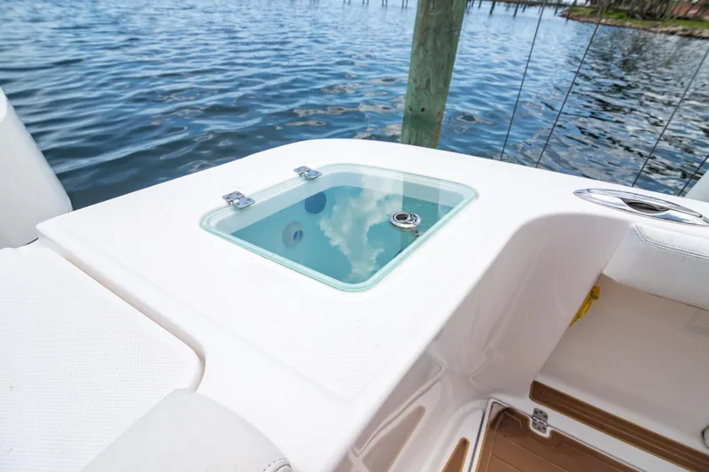 Slide: The Image of 2016 Edgewater 368CC boat with a clear livewell, docked by the water. - 7