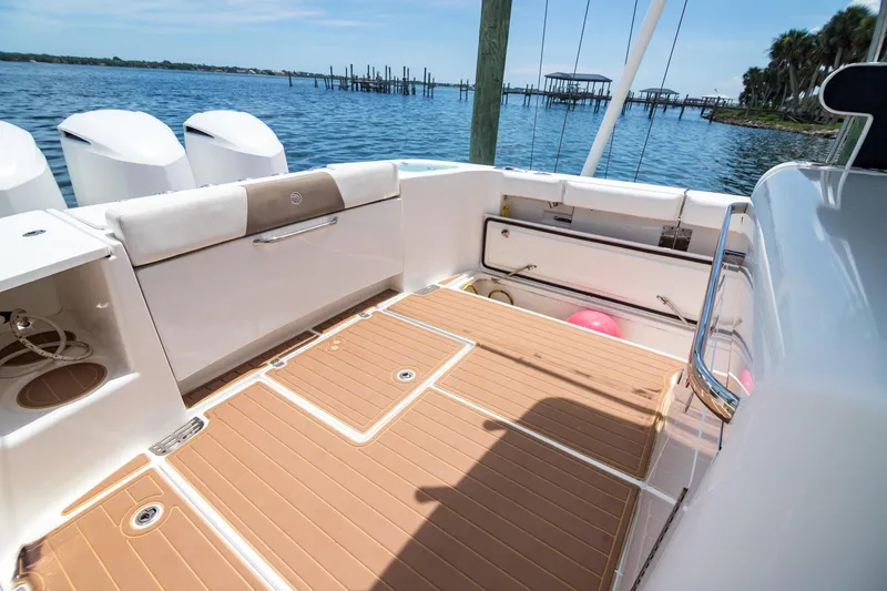 Slide: The Image of 2016 Edgewater 368CC boat deck with seating, storage, and scenic waterfront view. - 8