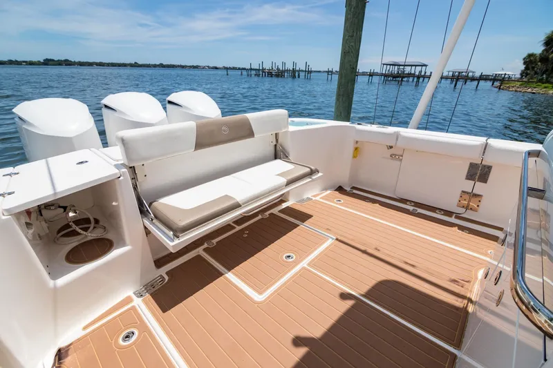 Slide: The Image of 2016 Edgewater 368CC boat deck with seating, overlooking serene waters and docks. - 9