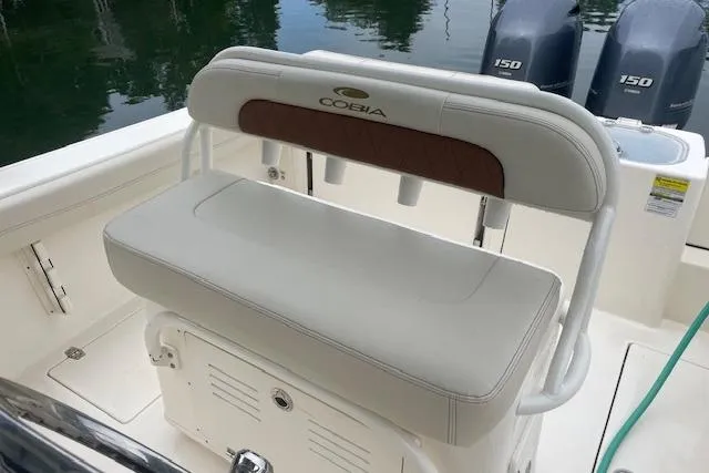 Slide: The Image of 2023 Cobia 240 Center Console boat seat with dual engines in the background. - 11